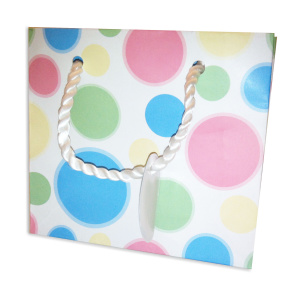 A gift bag with twisted rope handles and playful polka dot pattern in pastel pink, blue, and green, perfect for tucking in elegant gift card packaging.