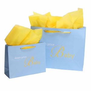 Two light blue gift bags with "dawn price Baby" written in yellow, each adorned with branded ribbons. The larger bag stands on the right, both containing bright yellow tissue paper peeking out. Yellow handles complete their charming look.