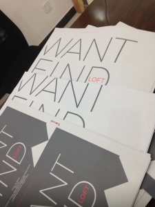A stack of magazines titled WANT FIND graces the dark wooden table, boasting a minimalist design with LOFT prominently highlighted in bold red text on the cover.