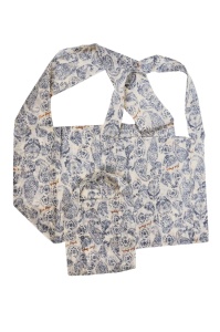 A chic floral-patterned muslin bag in a blue and white design, featuring long handles and a convenient small pocket attached to the front.