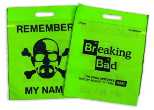 Two bright green bags with cutting-edge packaging showcase designs inspired by Breaking Bad. One bag features a glasses-and-hat illustration with "Remember My Name," while the other promotes the show's final episodes on AMC, stating "Breaking Bad" and the air date.