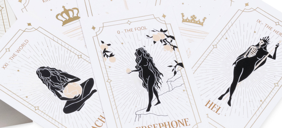 A close-up of three AWE Tarot cards depicts stylized figures in black silhouettes, each surrounded by subtle gold and white designs. The World, The Fool, and The Hermit are intricately illustrated with unique embellishments.