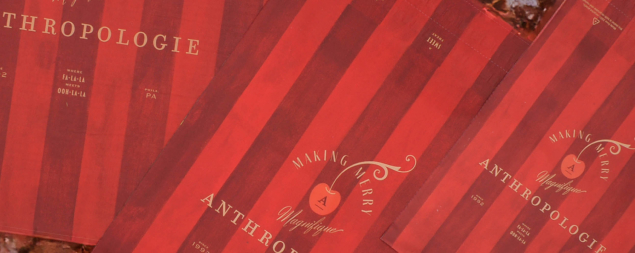 Red catalogs with Anthropologie and Making Merry text on striped holiday-themed covers, like a festive mailer bringing joy.